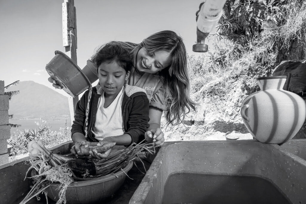 Una mujer y un niño leen juntos en una embarcación, fotografía de UNICEF